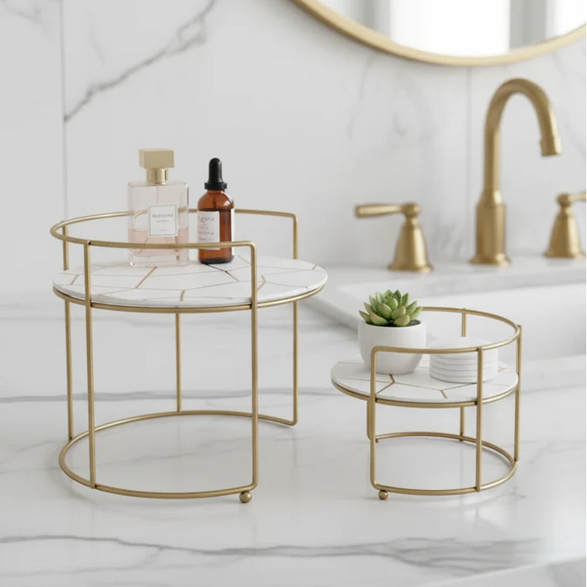 Round Marble Vanity Stands in white marble beside a gold faucet with succulent