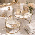 Round Marble Vanity Stands in white marble on a bathroom sink with perfume and towels